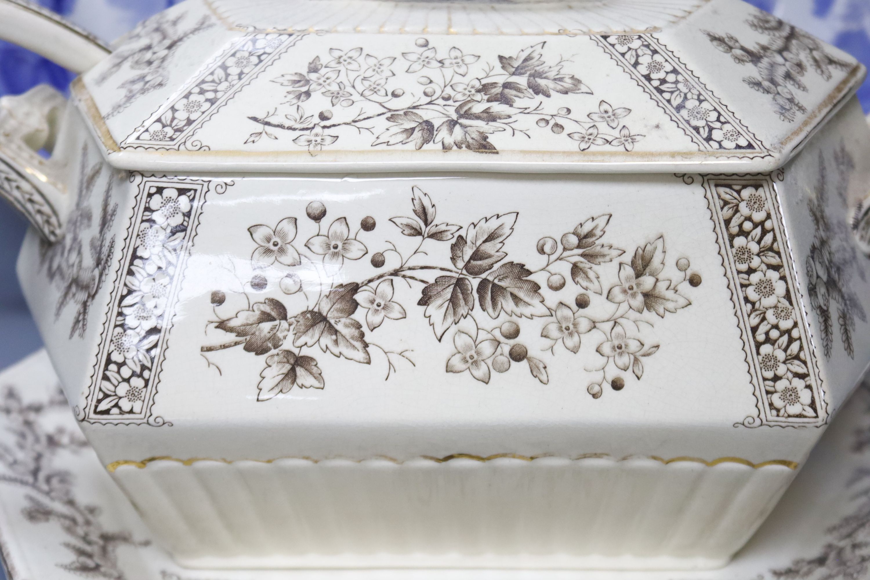 A late 19th century Staffordshire blue and white transfer-printed oval meat dish, ‘The Rokery’, depicting a country house with lake and figures, W 44cm and an octagonal 'Flora' creamware soup tureen with ladle and stand